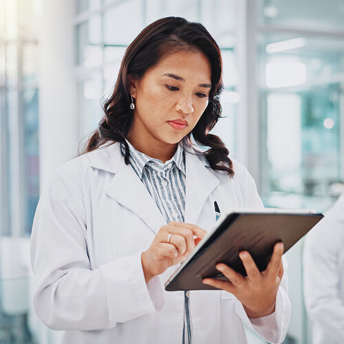 woman in glasses looking at data on a screen